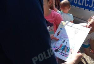 Kolorowanka dotycząca bezpieczeństwa w dłoniach policjantki.