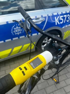 Alcoblow i rower na tle radiowozu