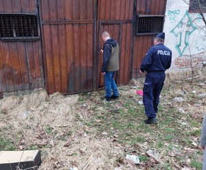 Policjant i pracownik MOPS podczas sprawdzania pustostanu