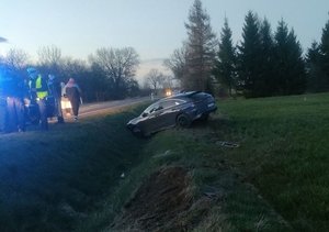 Auto w rowie oraz policjant pracujący na miejscu zdarzenia