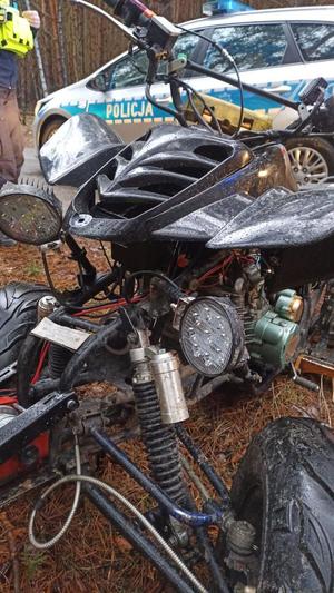 Na pierwszym planie uszkodzony quad, w tle radiowóz.