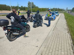 Policjanci przeprowadzający kontrolę motocykli.